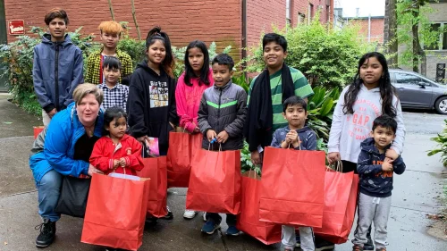 Volunteers from Serve with the Saints delivering grocery bags