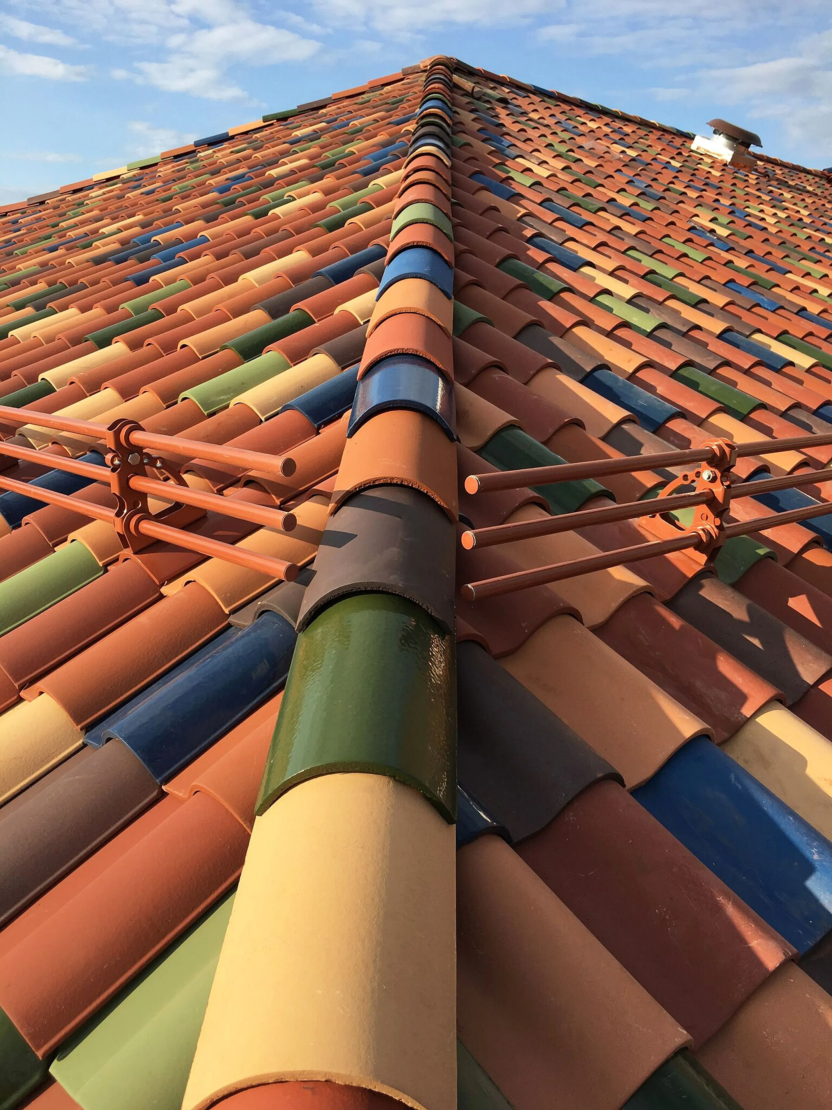 A ridge of glazed clay tiles in mixed colours, shot from below